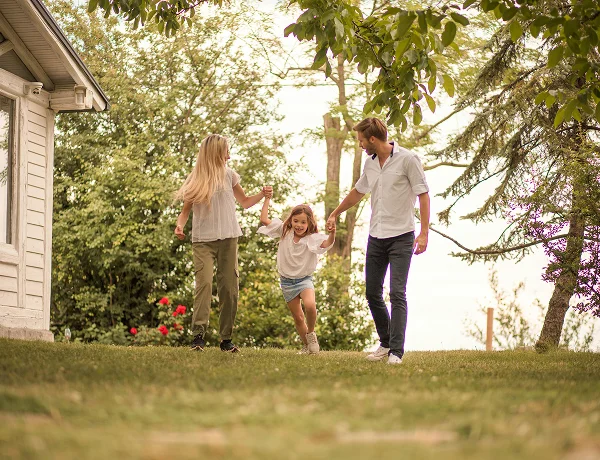 Family walking across the lawn beside their new home