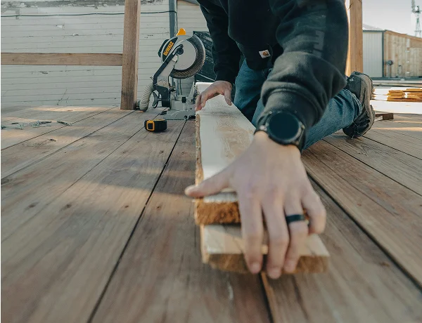 Builder measuring a decking board before cutting