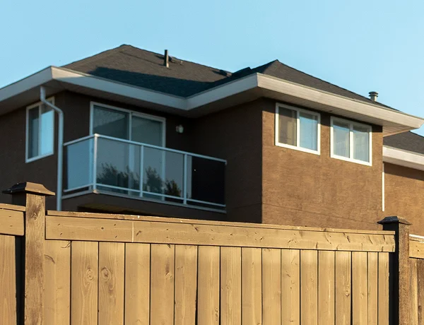 Timber paling fence providing privacy beside a two-storey home