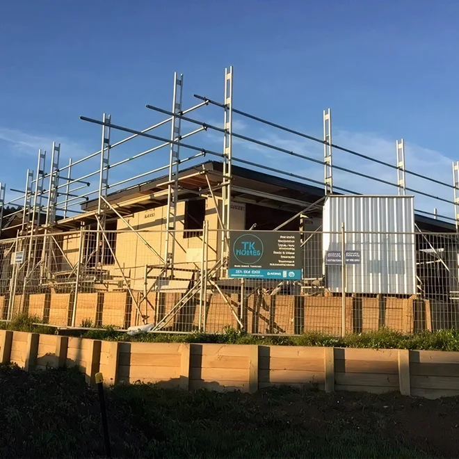 New home under construction in Tauranga with scaffolding around timber framing