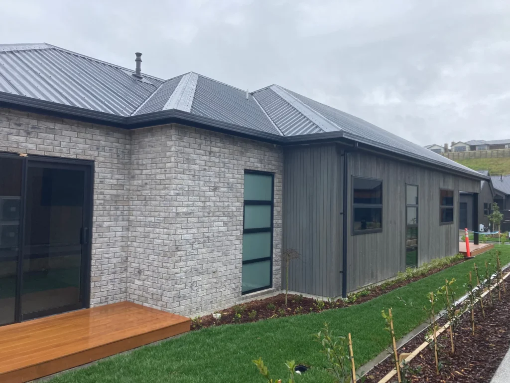 Brick and grey vertical cladding on a home completed with labour-only support